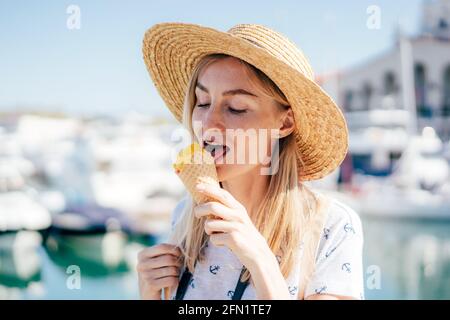 The girl eats ice cream sorbet in a waffle cone. Summer food. Delicious eating. Enjoyment. Stock Photo