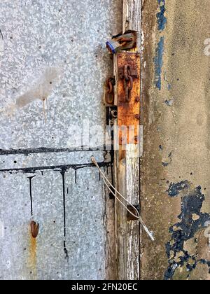 Broken chain and rusted padlock on exterior door Stock Photo