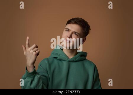 young handsome guy pointing finger up with successful idea Stock Photo