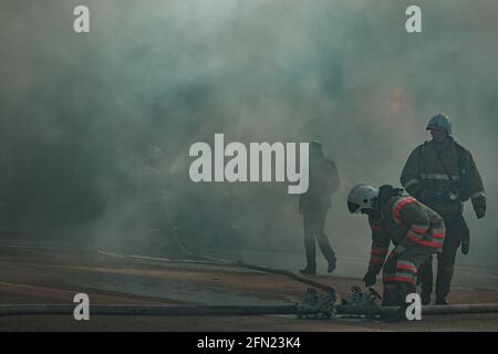 Rescuers firefighters extinguish a fire on the roof. The building after ...