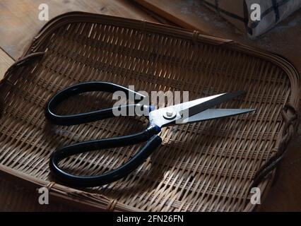 The scissors in the bamboo basket Stock Photo