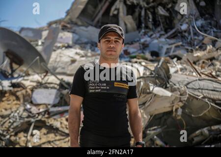 Gaza, Palestinian Territories. 12th May, 2021. The 29-year-old Palestinian Bashir al-Zaitunia stands before a pile of rubble. He says the situation in Gaza is 'appalling'. The Gaza conflict continues to escalate. (to dpa 'First day attack on Tel Aviv - dozens dead in Gaza') Credit: ;Saud Abu Ramadan/dpa/Alamy Live News Stock Photo