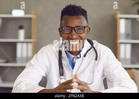 Headshot of happy young African American doctor in glasses looking at camera and smiling Stock Photo