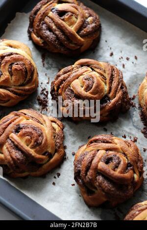 Bakery. Cinnamon Buns on Baking Tray. Breakfast Buttery Pastry. Stock Photo