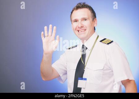 Mature smiling male pilot waving hand Stock Photo