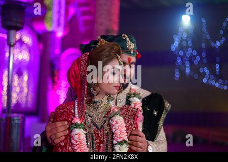gorgeous stunning indian bride and groom wearing traditionally dress are posing on their wedding ceremony. Stock Photo
