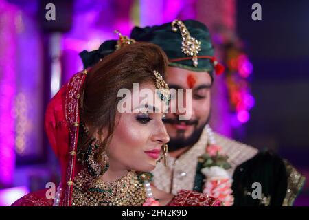 gorgeous stunning indian bride and groom wearing traditionally dress are posing on their wedding ceremony. Stock Photo