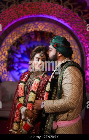 gorgeous stunning indian bride and groom wearing traditionally dress are posing on their wedding ceremony. Stock Photo