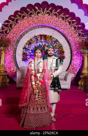 gorgeous stunning indian bride and groom wearing traditionally dress are posing on their wedding ceremony. Stock Photo