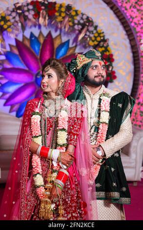 gorgeous stunning indian bride and groom wearing traditionally dress are posing on their wedding ceremony. Stock Photo