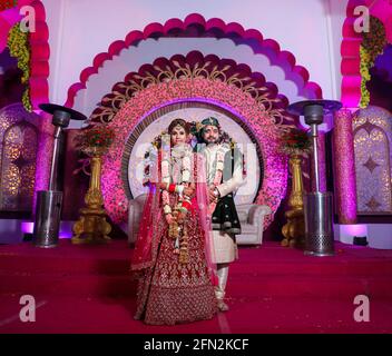 gorgeous stunning indian bride and groom wearing traditionally dress are posing on their wedding ceremony. Stock Photo