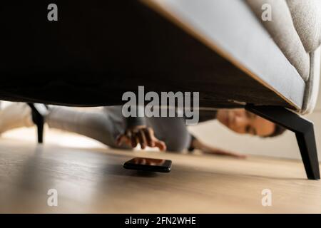 African Woman Found Lost Cell Phone Under Couch Stock Photo