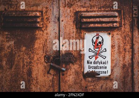 electrical device warning sign on rusty locker," electrical device! don't touch!" Stock Photo