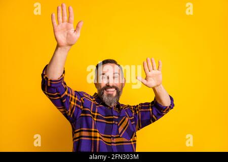 Photo portrait of aged man dancing at party in casual plaid shirt isolated on vivid yellow color background Stock Photo