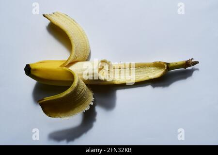 Half eaten Banana ,partially pealed, ripe yellow,healthy nutricious snack. Stock Photo