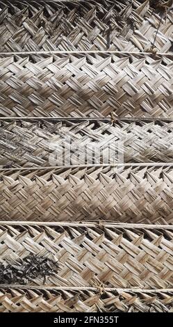 Dried woven palm leaf wall, natural background. Stock Photo