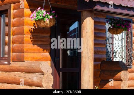 Fragment of log wooden house with decorated entrance. Rural scene. country lifestyle. Stock Photo