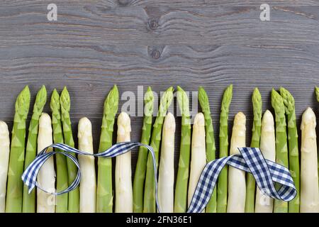 Fresh Bavarian white and green asparagus from Schrobenhausen in a row on dark wood with copy space Stock Photo