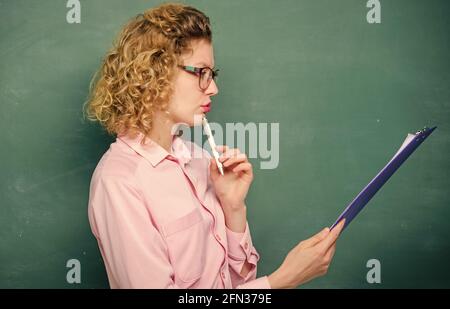 Literature teacher read composition. Read impressing resume. Tutor checking homework. Woman smart lady hold tablet documents. Read personal profile Stock Photo