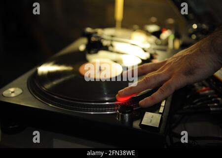 DJ plays live set and mixing music on turntable in the night club. station at club party. DJ mixer controller panel for playing music and partying. Stock Photo