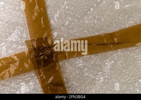 Adhesive tape on a bubble wrap. Abstract plastic background. Delivery Concept Stock Photo