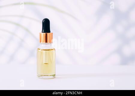 Serum or essential oil bottle on light background. Natural organic cosmetic Stock Photo