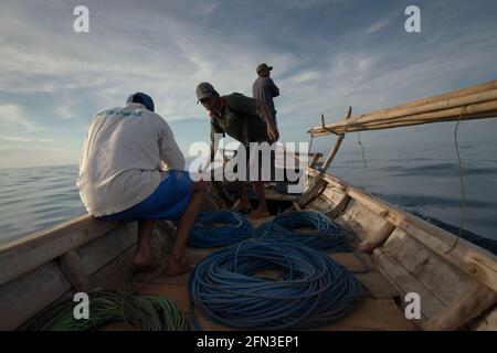 Whale hunters on traditional whaling boat equipped with bamboo harpoons and ropes, that is sailing on Savu Sea off the coast of Lamalera in Wulandoni, Lembata, East Nusa Tenggara, Indonesia. Stock Photo