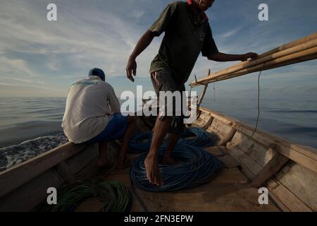 Whale hunters on traditional whaling boat equipped with bamboo harpoons and ropes, that is sailing on Savu Sea off the coast of Lamalera in Wulandoni, Lembata, East Nusa Tenggara, Indonesia. Stock Photo