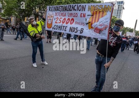 Barcelona, Spain. 13th May, 2021. Two protesters hold a banner during the demonstration.Hundreds of workers from the Japanese car company Nissan in Catalonia as well as those from subcontracted companies have demonstrated in front of the Delegation of the Government of Spain in Catalonia to ask for the reindustrialization of the sector to avoid layoffs that affect 25,000 families. (Photo by Paco Freire/SOPA Images/Sipa USA) Credit: Sipa USA/Alamy Live News Stock Photo