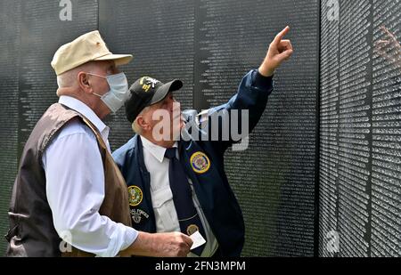 Tunkhannock, United States. 13th May, 2021. A veteran helps a masked veteran find the name of a man that died in his unit in Vietnam on the Wall that Heals.The Wall That Heals is a three-quarter scale replica of the Vietnam Veterans Memorial in Washington, DC, the wall travels around the country and is set up and displayed for 24 hours a day while it is in place. (Photo by Aimee Dilger/SOPA Images/Sipa USA) Credit: Sipa USA/Alamy Live News Stock Photo