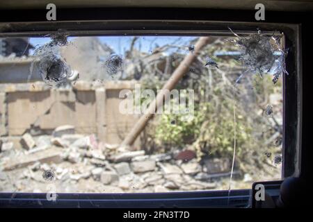Destruction of buildings as seen through a damaged Humvee window in West Mosul during the 2016-2017 Mosul Operation. Stock Photo