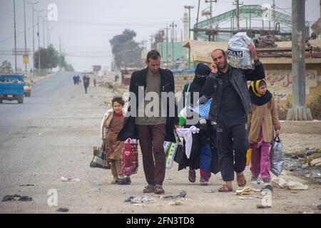 A family flees the ongoing conflict on one of the roads going into Mosul from the east near Gogjali, East Mosul, Iraq. Stock Photo