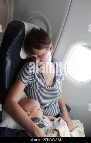 Woman with baby are sleeping on the flight Stock Photo