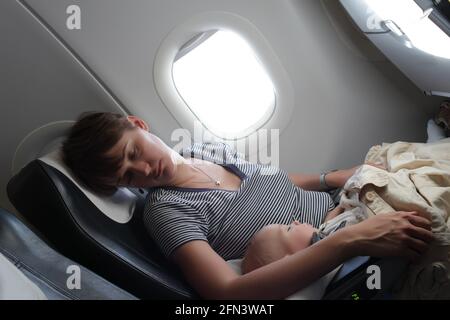 Mother and her son are sleeping on the board Stock Photo