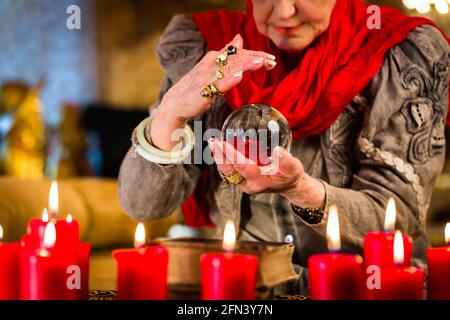 Female Fortuneteller or esoteric Oracle, sees in the future by looking into their crystal ball Stock Photo