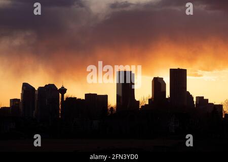 Yellow, orange and purple sunset sky over downtown Calgary skyline, Alberta, Canada Stock Photo