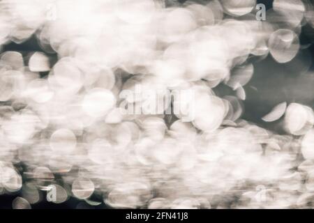 Abstract nature summer ocean sunset sea background. Small waves on water surface in motion blur with bokeh lights from sunrise. Holiday, vacation and Stock Photo