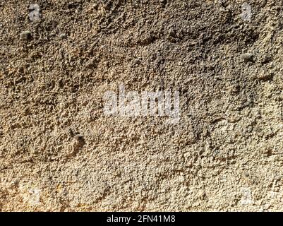 Aged material of masonry concept. Old weathered exterior cement wall construction background texture. Brown rough worn faded dirty concrete surface bl Stock Photo