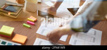 Cropped shot of ui designer team working on smartphone application together Stock Photo