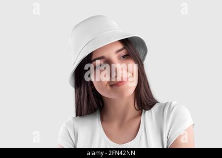 Mockup of a white panama on a dark-haired girl in a T-shirt, close-up, isolated on background, front view. Fashion headwear template, universal sun pr Stock Photo