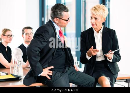 Business - meeting in office, two senior managers are discussing a document on tablet computer Stock Photo