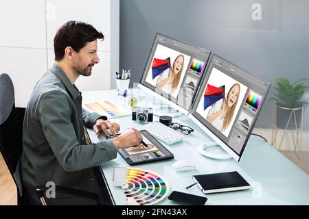 Graphic Photo Designer Using Computer Screen And Tablet Stock Photo