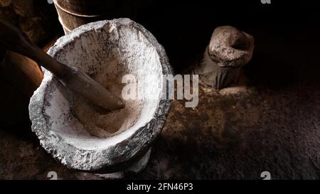 Ancient flour mortar. Wooden vessel for manual hand grinding. Authentic craft workshop. This method has been in use for many thousand years. Stock Photo