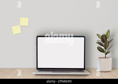 Cropped shot of minimal workspace with mock-up laptop, plant, decorations and copy space. Stock Photo