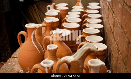 Close-up photo of clay jugs. Rows of handmade earthenware jugs. Handicraft products Stock Photo