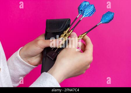 Choosing a dart. Three darts in the hands of the player. Stock Photo
