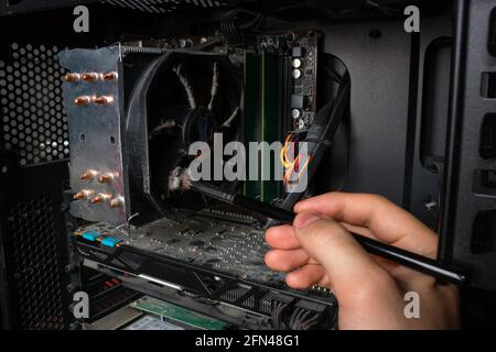 Computer Technology Engineer removes dust from PC hardware Stock Photo