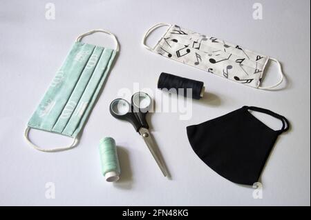 Three type of DIY fabric cotton face mask with scissors and spool of tread on white background Stock Photo