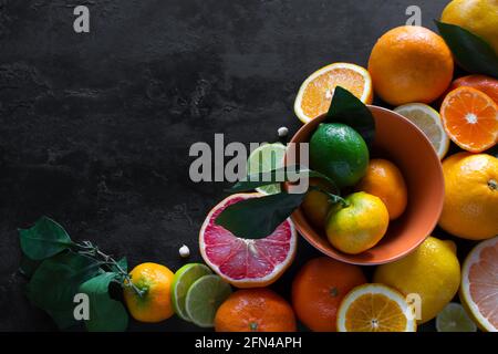 sliced fresh citruses grapefruits, tangerines and lime on a black background with place for text. vitamin c concept Stock Photo