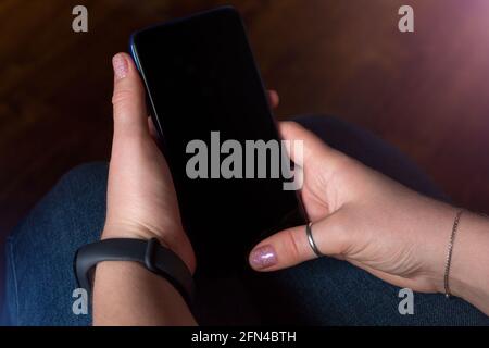 hands holding a mobile phone with a blank black screen mockup image Stock Photo